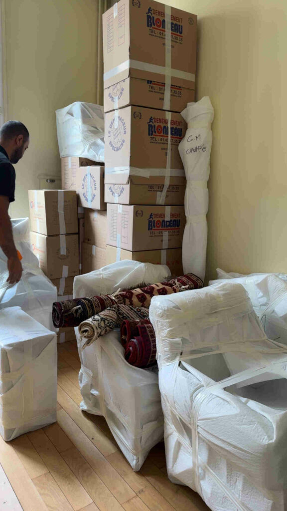 Déménageurs professionnels Blondeau chargeant des meubles et cartons avec soin pour un senior, avec protections et organisation