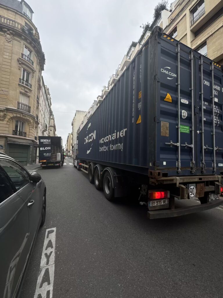 Déménageurs utilisant un diable et protections pour transporter des meubles dans le 10ᵉ arrondissement de Paris.