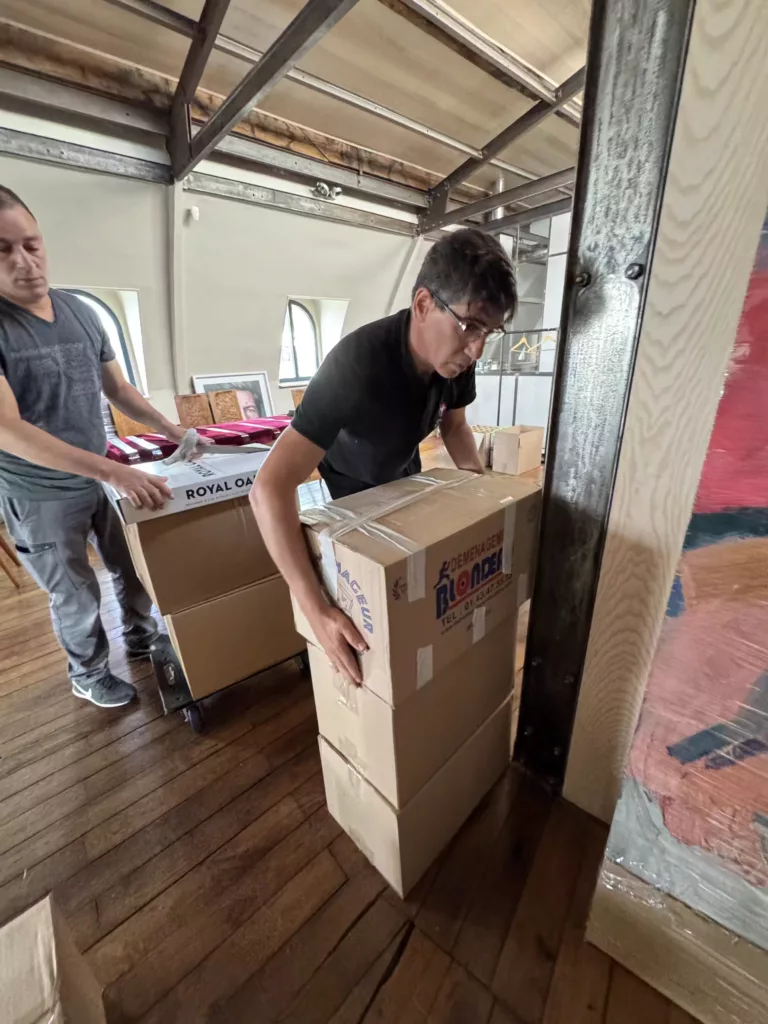 Personnes emballant du mobilier de bureau et équipements pour un déménagement professionnel bien planifié.