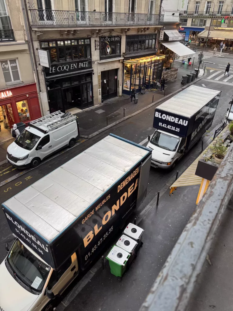 Camion de déménagement stationné avec panneaux de signalisation et protections autour pour sécuriser l’accès et la circulation.